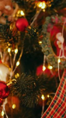 Dikey. Geleneksel Noel ağacı kırmızı süslemelerle süslenmiş. Güzel dekore edilmiş Noel ağacı olan şenlik odası. Kırmızı takılar bir tatil ağacına renk katıyor. Samimi ayarlar