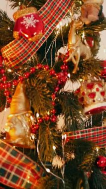 Dikey. Geleneksel Noel ağacı kırmızı süslemelerle süslenmiş. Güzel dekore edilmiş Noel ağacı olan şenlik odası. Kırmızı takılar bir tatil ağacına renk katıyor. Samimi ayarlar