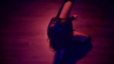 Baştan çıkarıcı dans eden seksi kadın. Yüksek topuklu bir dansçı, canlı renklerle yıkanmış, sahnenin heyecan verici enerjisini somutlaştırıyor. Akışkan hareketler, yüksek topuklar ve büyüleyici bir göz alıcı performans loş alanı ateşler. Sahnede Geceçöküşü