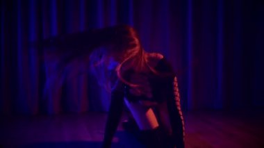 Baştan çıkarıcı dans eden seksi kadın. Yüksek topuklu bir dansçı, canlı renklerle yıkanmış, sahnenin heyecan verici enerjisini somutlaştırıyor. Akışkan hareketler, yüksek topuklar ve büyüleyici bir göz alıcı performans loş alanı ateşler. Sahnede Geceçöküşü