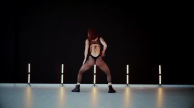 A dancer girl with a big ass in a thong dances erotically in hall. A captivating twerk, showcasing powerful movement and rhythm. Sexy woman dancing a seductive dance. Twerking, high heels, striptease.Energy and passion radiate from the performer's 