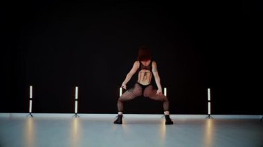 A dancer girl with a big ass in a thong dances erotically in hall. A captivating twerk, showcasing powerful movement and rhythm. Sexy woman dancing a seductive dance. Twerking, high heels, striptease.Energy and passion radiate from the performer's 
