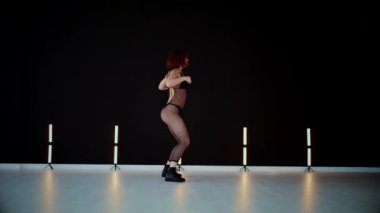 A dancer girl with a big ass in a thong dances erotically in hall. A captivating twerk, showcasing powerful movement and rhythm. Sexy woman dancing a seductive dance. Twerking, high heels, striptease.Energy and passion radiate from the performer's 