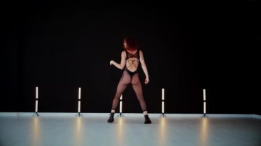 A dancer girl with a big ass in a thong dances erotically in hall. A captivating twerk, showcasing powerful movement and rhythm. Sexy woman dancing a seductive dance. Twerking, high heels, striptease.Energy and passion radiate from the performer's 