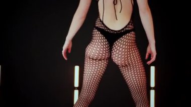 A dancer girl with a big ass in a thong dances erotically in hall. A captivating twerk, showcasing powerful movement and rhythm. Sexy woman dancing a seductive dance. Twerking, high heels, striptease.Energy and passion radiate from the performer's 