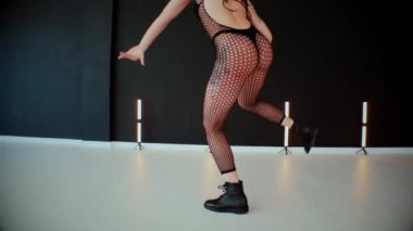 A dancer girl with a big ass in a thong dances erotically in hall. A captivating twerk, showcasing powerful movement and rhythm. Sexy woman dancing a seductive dance. Twerking, high heels, striptease.Energy and passion radiate from the performer's 
