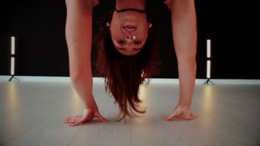 A dancer girl with a big ass in a thong dances erotically in hall. A captivating twerk, showcasing powerful movement and rhythm. Sexy woman dancing a seductive dance. Twerking, high heels, striptease.Energy and passion radiate from the performer's 
