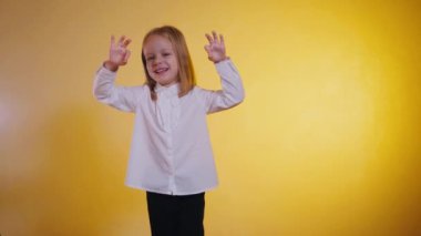 Kendine güveni olan genç bir kız canlı sarı bir arkaplan karşısında 