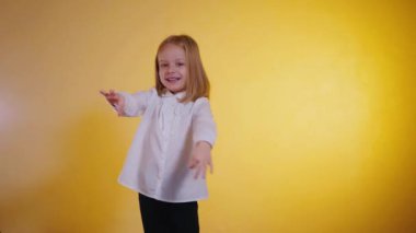 Kendine güveni olan genç bir kız canlı sarı bir arkaplan karşısında 