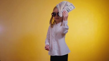 Kendinden emin gülümseyen bir çocuk para dolarlarını hayranı gibi elinde tutuyor. Beyaz gömlekli, ciddi bir iş kızı, kendine güvenen, satın almaya hazır bir para tutuyor. İş gibi, güneş gözlüklü bir çocuk, çok para gösteriyor.. 