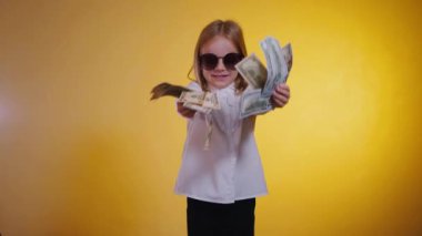 Kendinden emin gülümseyen bir çocuk para dolarlarını hayranı gibi elinde tutuyor. Beyaz gömlekli, ciddi bir iş kızı, kendine güvenen, satın almaya hazır bir para tutuyor. İş gibi, güneş gözlüklü bir çocuk, çok para gösteriyor.. 