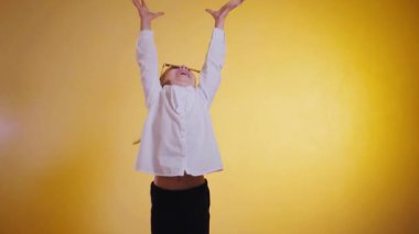 Mutlu kız para kusuyor. Kağıt para, mutlu bir kızın etrafında dans eder. Para mutlu bir çocuğun üzerine yağar, kolları neşe içinde parlak bir arka plana karşı kaldırılır. Yavaş çekim. Parayla yıkanmış neşeli bir çocuk.