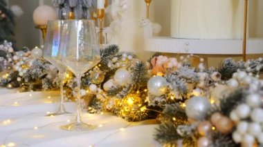 Narin süslemelerle süslenmiş şenlikli ağaçlar güzel bir sehpanın başında nöbet tutarlar. Zarif Noel süsleri. Hediyeler ve ağaçlar sıcak ve davetkar bir atmosfer yaratır. Bir Noel ziyafeti bekliyor. İkramlarla ve parıldayan ışıklarla dolu bir masa,