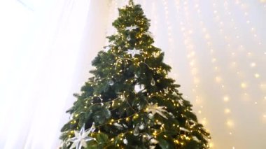 Işıl ışıl buz saçakları ve pırıl pırıl ışıklar, narin, dağınık bir ışıkla yıkanmış, şenlikli bir köknarı süslüyor. Minyatür bir mum ve yıldızdan gelen yumuşak, sıcak bir parıltı, bir Noel ağacının zümrüt dallarının arasına yerleşmiş..