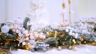 Narin süslemelerle süslenmiş şenlikli ağaçlar güzel bir sehpanın başında nöbet tutarlar. Zarif Noel süsleri. Hediyeler ve ağaçlar sıcak ve davetkar bir atmosfer yaratır. Bir Noel ziyafeti bekliyor. İkramlarla ve parıldayan ışıklarla dolu bir masa,