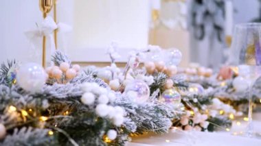 Narin süslemelerle süslenmiş şenlikli ağaçlar güzel bir sehpanın başında nöbet tutarlar. Zarif Noel süsleri. Hediyeler ve ağaçlar sıcak ve davetkar bir atmosfer yaratır. Bir Noel ziyafeti bekliyor. İkramlarla ve parıldayan ışıklarla dolu bir masa,