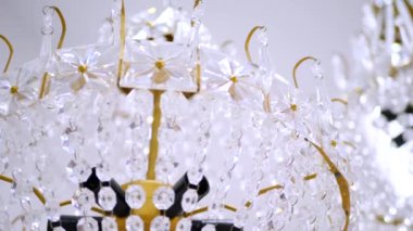 Parlak kristal avize, göz kamaştırıcı bir parıltı. Havada asılı duran bir dizi berrak kristal. Zarif, süslü bir avize, mekanı aydınlatıyor. Yaldızlı çerçeve, kristal gözyaşları, nefes kesici bir fikstür.