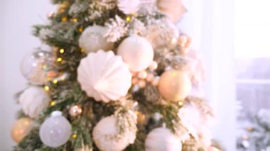 Narin bir kar yağışı ile süslenmiş Noel ağacı dalları. Zarif süsler sergiliyor. Güzel dekore edilmiş bir Noel ağacının yakın çekimi. Zarif süsler ve yanıp sönen ışıklar sergileniyor. Narin, karlı süsler, yavaşça parıldıyor. 