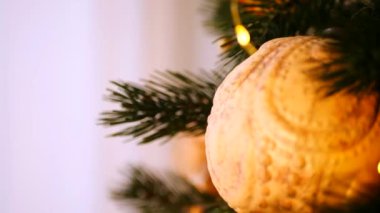 Sıcak, altın ışıklar ve el yapımı süslemelerle süslenmiş Noel ağacı. Noel ağacı dalları, parlak ışıklar, ve el yapımı saman yıldızı, turuncu, sıcak ve davetkar bir atmosfer yaratıyor. Peri ışıklarının yumuşak parıltısı aydınlatır