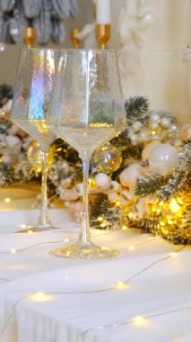 Hassas süslemelerle süslenmiş dikey, şenlikli ağaçlar güzel bir masanın başında nöbet tutarlar. Zarif bir Noel dekoru. Hediyeler ve ağaçlar sıcak ve davetkar bir atmosfer yaratır. Bir Noel ziyafeti bekliyor..