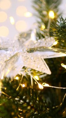 Dikey, ışıldayan buz saçakları ve parıldayan ışıklar, narin, dağınık bir ışıkla yıkanmış, bayram köknarı süslüyor. Minyatür bir mum ve yıldızdan gelen yumuşak, sıcak bir parıltı, bir Noel ağacının zümrüt dallarının arasına yerleşmiş.