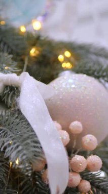 Dikey, Noel ağacı dalları, narin bir kar yağışı ile süslenmiş, zarif süsler sergiliyor. Süslü bir Noel ağacının yakın çekimi. Zarif süsler ve parıldayan ışıklar sergiliyor..