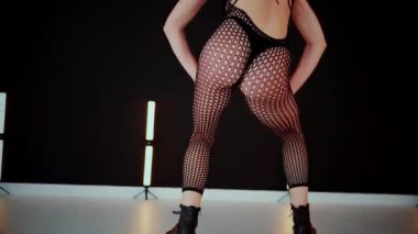 Büyük kalçalı, tangalı bir dansçı kız koridorda erotik bir şekilde dans ediyor. Büyüleyici bir twerk, güçlü bir hareket ve ritim sergiliyor. Baştan çıkarıcı dans eden seksi kadın. Kıvranma, yüksek topuklar, striptiz..