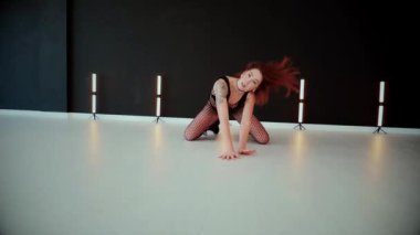 Büyük kalçalı, tangalı bir dansçı kız koridorda erotik bir şekilde dans ediyor. Büyüleyici bir twerk, güçlü bir hareket ve ritim sergiliyor. Baştan çıkarıcı dans eden seksi kadın. Kıvranma, yüksek topuklar, striptiz..