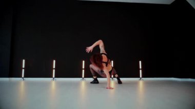 Büyük kalçalı, tangalı bir dansçı kız koridorda erotik bir şekilde dans ediyor. Büyüleyici bir twerk, güçlü bir hareket ve ritim sergiliyor. Baştan çıkarıcı dans eden seksi kadın. Kıvranma, yüksek topuklar, striptiz..