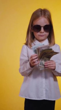 Dikey, kendinden emin gülümseyen bir çocuk para dolarlarını hayranı gibi elinde tutuyor. Beyaz gömlekli, ciddi, genç bir iş kızı, kendine güveniyor ve para sayıyor, satın almaya hazır. İş gibi.,