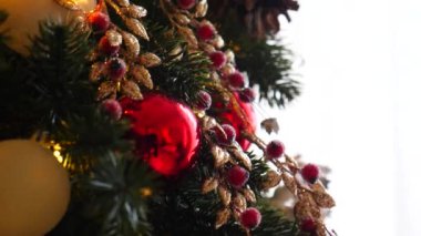 Narin bir kar yağışı ile süslenmiş Noel ağacı dalları. Zarif süsler sergiliyor. Güzel dekore edilmiş bir Noel ağacının yakın çekimi. Zarif süsler ve yanıp sönen ışıklar sergileniyor..