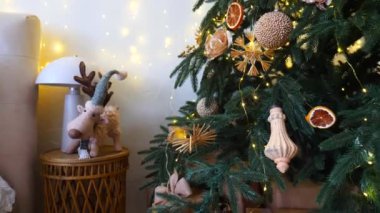 Yeni yıl oyuncak geyiği. Narin bir kar yağışı ile süslenmiş Noel ağacı dalları. Zarif süsler sergiliyor. Süslü bir Noel ağacının yakın çekimi. Zarif süsler ve parıldayan ışıklar sergiliyor..