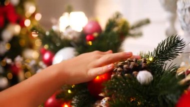 Narin bir kar yağışı ile süslenmiş Noel ağacı dalları. Zarif süsler sergiliyor. Güzel dekore edilmiş bir Noel ağacının yakın çekimi. Zarif süsler ve yanıp sönen ışıklar sergileniyor..
