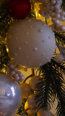 Dikey, Noel ağacı dalları, narin bir kar yağışı ile süslenmiş, zarif süsler sergiliyor. Güzel dekore edilmiş bir Noel ağacının yakın çekimi. Zarif süsler sergiliyor. 