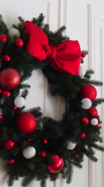 Dikey, geleneksel Noel ağacı kırmızı süslemelerle süslenmiş. Güzel dekore edilmiş Noel ağacı olan şenlik odası. Kırmızı takılar bir tatil ağacına renk katıyor. Samimi ayarlar