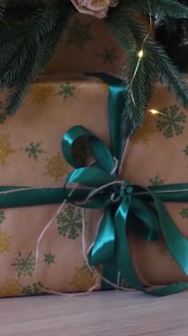 Dikey, parıldayan bir Noel ağacının altında bir sürü güzel yuva hediyeleri. Noel neşesi, güzel paketlenmiş hediyeler ve şenlikli ışıklardan gelen hafif bir parıltı..