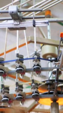 Dikey, arabalara kumaş dokuma. Fabrikadaki ipliklerden kumaş üretimi. Tekstil fabrikası endüstrisi. Kumaş yapma makineleri.