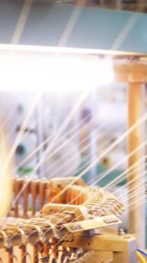 Dikey, arabalara kumaş dokuma. Fabrikadaki ipliklerden kumaş üretimi. Tekstil fabrikası endüstrisi. Kumaş yapma makineleri.