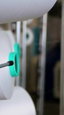 Dikey, arabalara kumaş dokuma. Fabrikadaki ipliklerden kumaş üretimi. Tekstil fabrikası endüstrisi. Kumaş yapma makineleri.