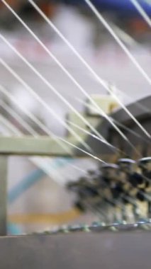 Dikey, arabalara kumaş dokuma. Fabrikadaki ipliklerden kumaş üretimi. Tekstil fabrikası endüstrisi. Kumaş yapma makineleri.