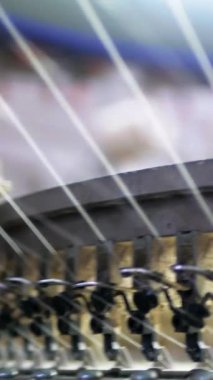 Dikey, arabalara kumaş dokuma. Fabrikadaki ipliklerden kumaş üretimi. Tekstil fabrikası endüstrisi. Kumaş yapma makineleri.