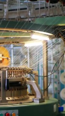 Dikey, arabalara kumaş dokuma. Fabrikadaki ipliklerden kumaş üretimi. Tekstil fabrikası endüstrisi. Kumaş yapma makineleri.