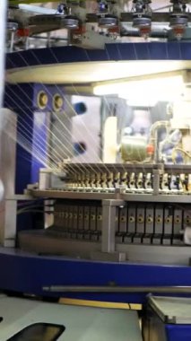 Dikey, arabalara kumaş dokuma. Fabrikadaki ipliklerden kumaş üretimi. Tekstil fabrikası endüstrisi. Kumaş yapma makineleri.