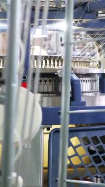 Dikey, arabalara kumaş dokuma. Fabrikadaki ipliklerden kumaş üretimi. Tekstil fabrikası endüstrisi. Kumaş yapma makineleri.