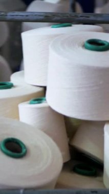 Dikey, arabalara kumaş dokuma. Fabrikadaki ipliklerden kumaş üretimi. Tekstil fabrikası endüstrisi. Kumaş yapma makineleri.