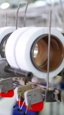 Dikey, arabalara kumaş dokuma. Fabrikadaki ipliklerden kumaş üretimi. Tekstil fabrikası endüstrisi. Kumaş yapma makineleri.