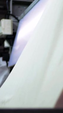 Dikey, arabalara kumaş dokuma. Fabrikadaki ipliklerden kumaş üretimi. Tekstil fabrikası endüstrisi. Kumaş yapma makineleri.