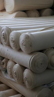 Dikey, arabalara kumaş dokuma. Fabrikadaki ipliklerden kumaş üretimi. Tekstil fabrikası endüstrisi. Kumaş yapma makineleri.