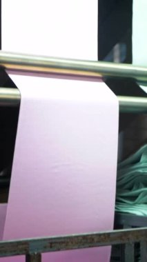 Dikey, arabalara kumaş dokuma. Fabrikadaki ipliklerden kumaş üretimi. Tekstil fabrikası endüstrisi. Kumaş yapma makineleri.