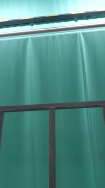 Dikey, arabalara kumaş dokuma. Fabrikadaki ipliklerden kumaş üretimi. Tekstil fabrikası endüstrisi. Kumaş yapma makineleri.